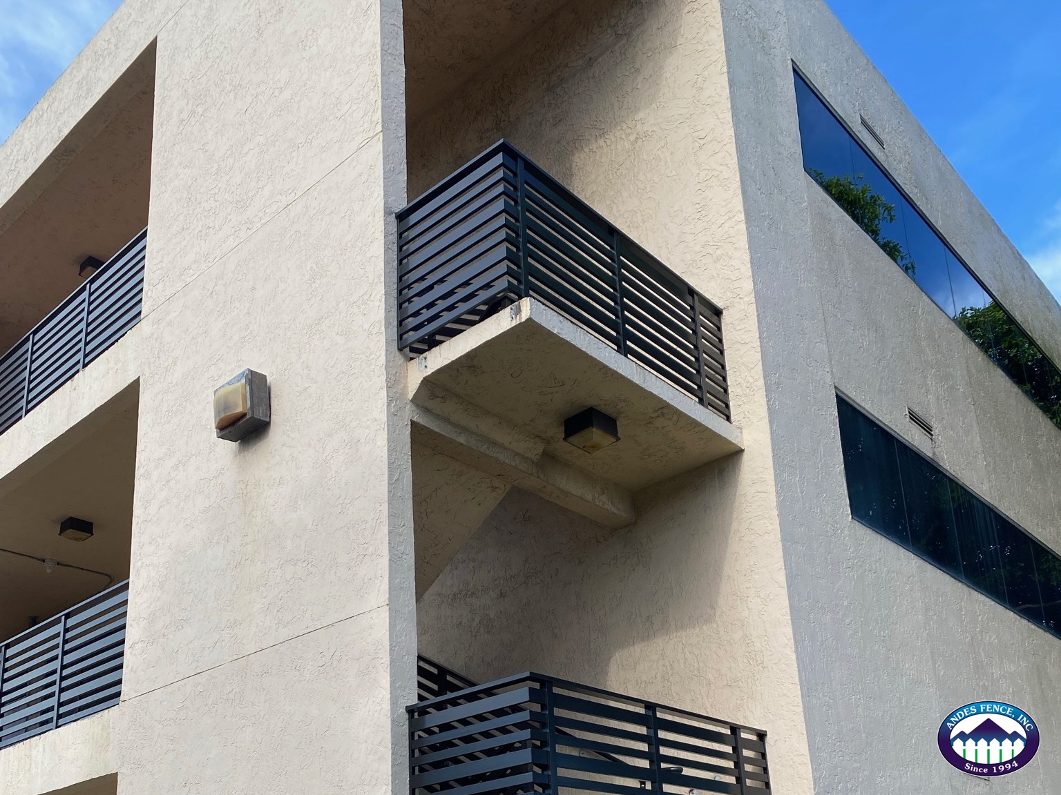 Dark horizontal railing sections on exterior balconies in an Andes Fence project photo.