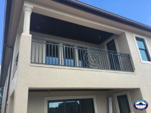 Decorative gray balcony railing with vertical pickets and a circular center detail on an Andes Fence project.