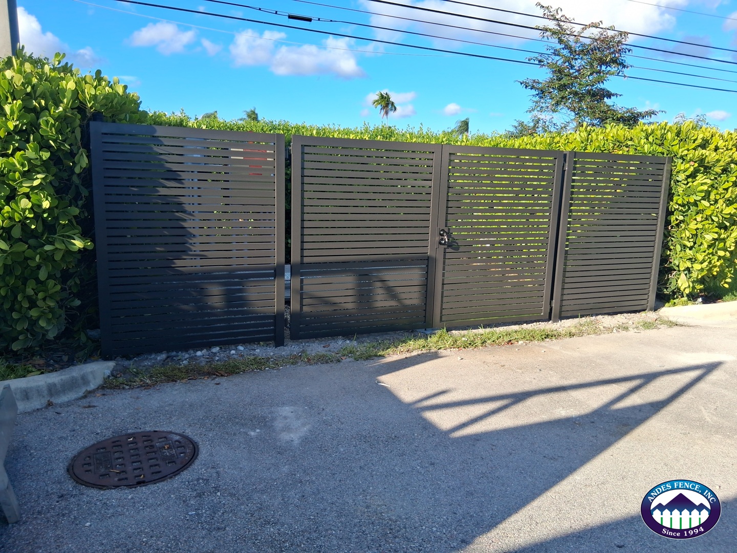Dark horizontal slat fence with a matching double gate, installed by Andes Fence