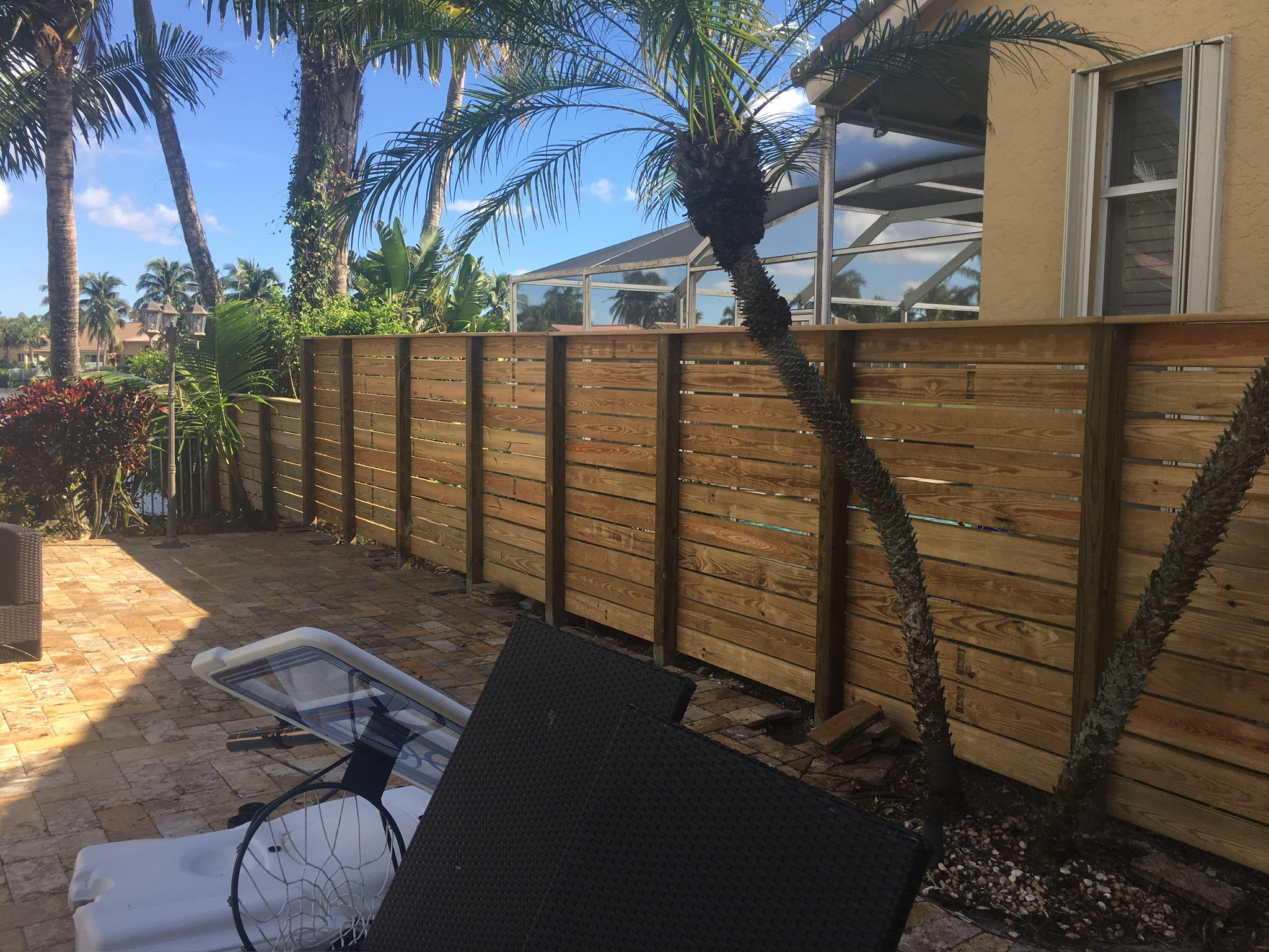 Horizontal wood fence with visible support posts beside a residential patio, completed by Andes Fence.